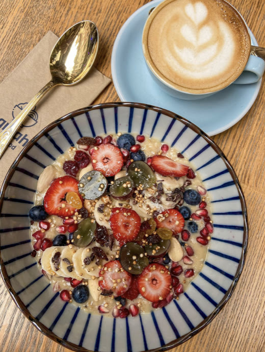 Porridge-Bowl mit Beeren und Kaffee